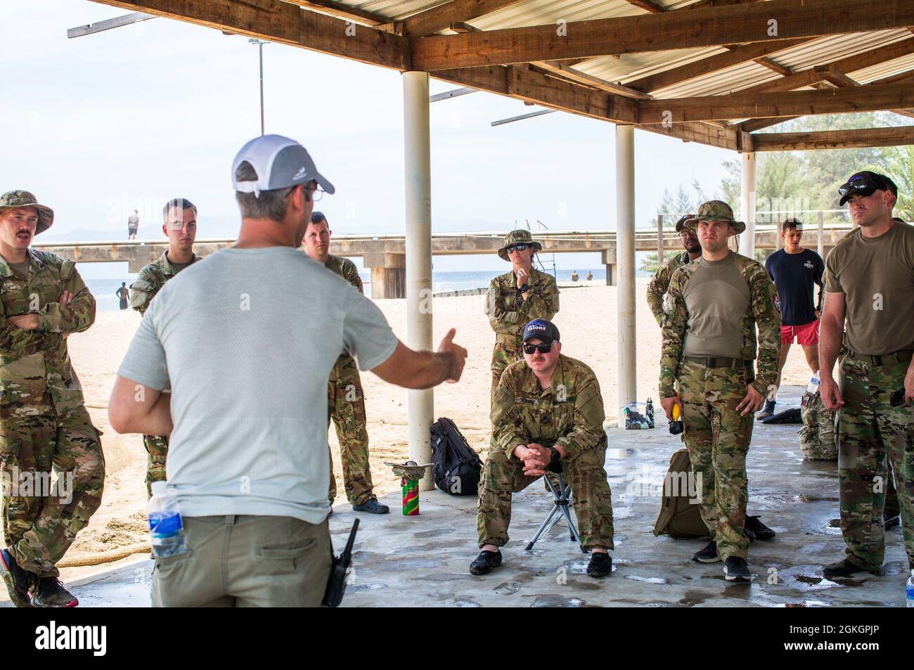 U.S. Army Major Brian Molloy, a cast master assigned to Joint Task Force-Bravo, briefs service members on in-flight commands for helocast during overwater survival training at Puerto Castilla, Honduras, April 17, 2021. The training is used to certify aircrews on overwater flight operations, and individual and crew emergency egress, ditching, water survival, passenger procedures and water recovery operations. Stock Photo