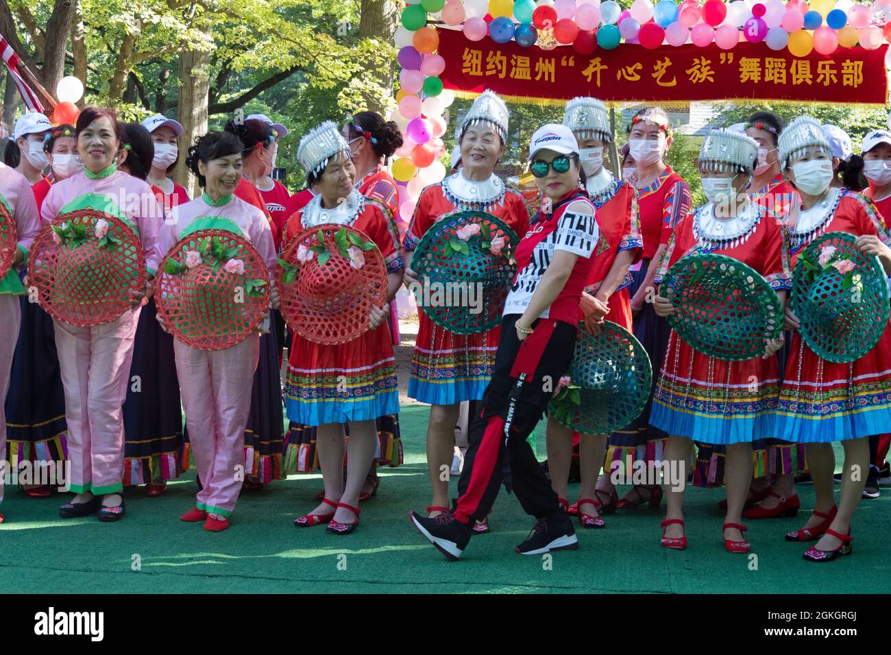 A women clowns for the cameras as members of Kai Xin Yizhu dance troupe prepare for a group photo prior to a performance. In Queens, New York. Stock Photo