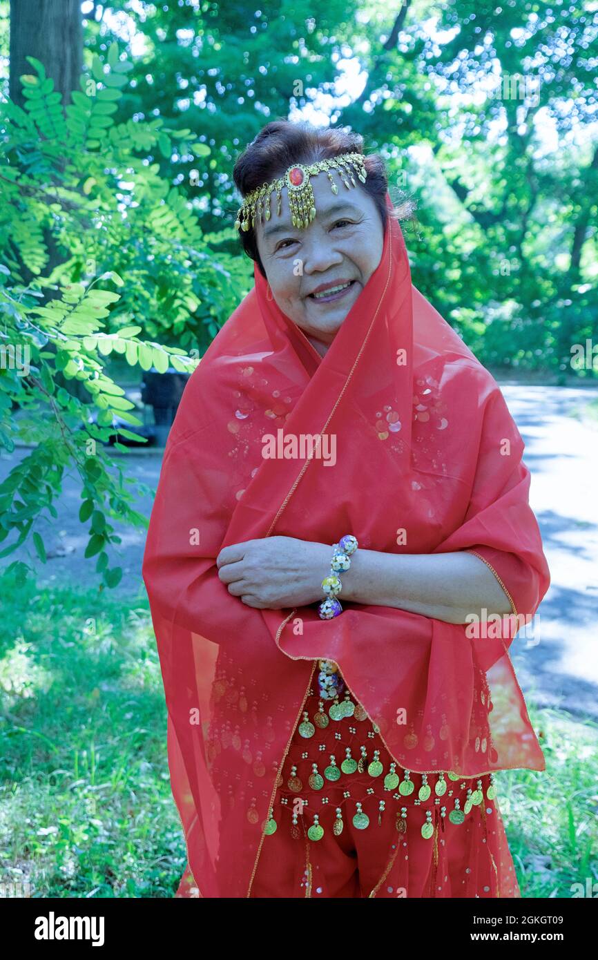Posed portrait of a woman in the Kai Xin Yizhu dance troupe. After a performance celebrating the groups anniversary. In Queens, New York. Stock Photo