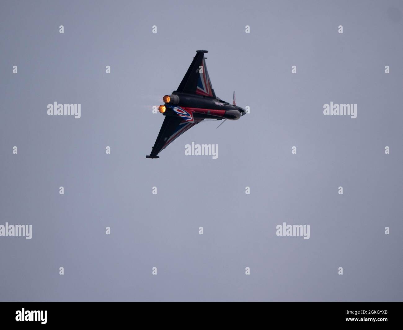 RAF Typhoon fighter jet rolling into inverted position with full afterburners on at the 2021 Bournemouth Air Display. Stock Photo
