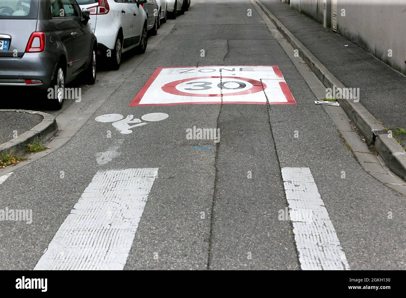 France, Valence, 2021-09-03. Illustration of a zone 30 announced by a ground inscription with a bicycle logo for the cycle track and a pedestrian cros Stock Photo