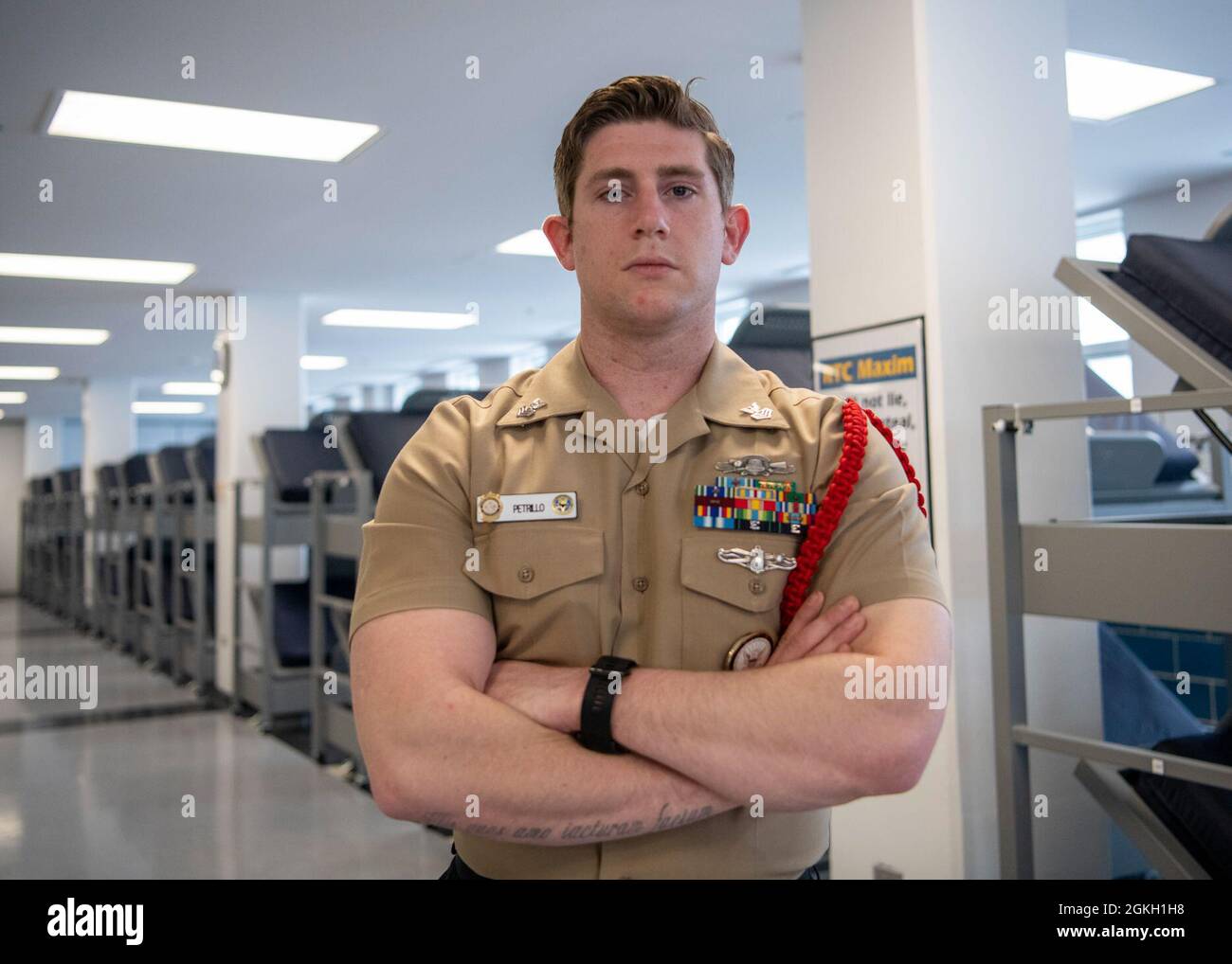 Information Systems Technician 1st Class Dan Petrillo, a recruit division commander, poses for a portrait inside the USS Marvin Shields recruit barracks at Recruit Training Command. More than 40,000 recruits train annually at the Navy's only boot camp. Stock Photo