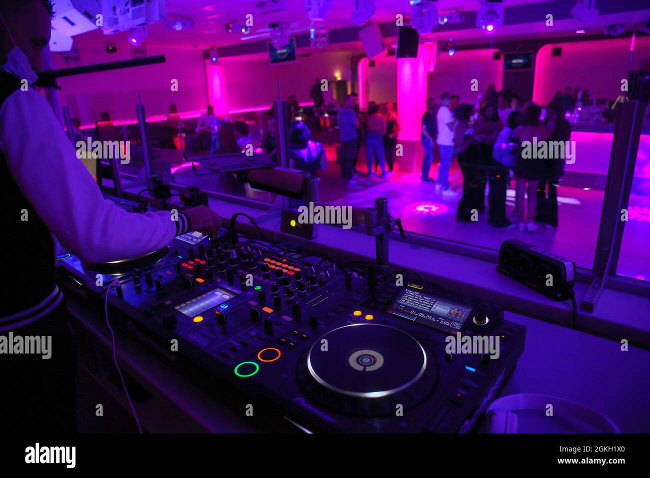 France, Saint Peray, 2021-08-28. A DJ mixes on his decks while young people dance on the dance floor. After more than 17 months of closure, the Seven Stock Photo