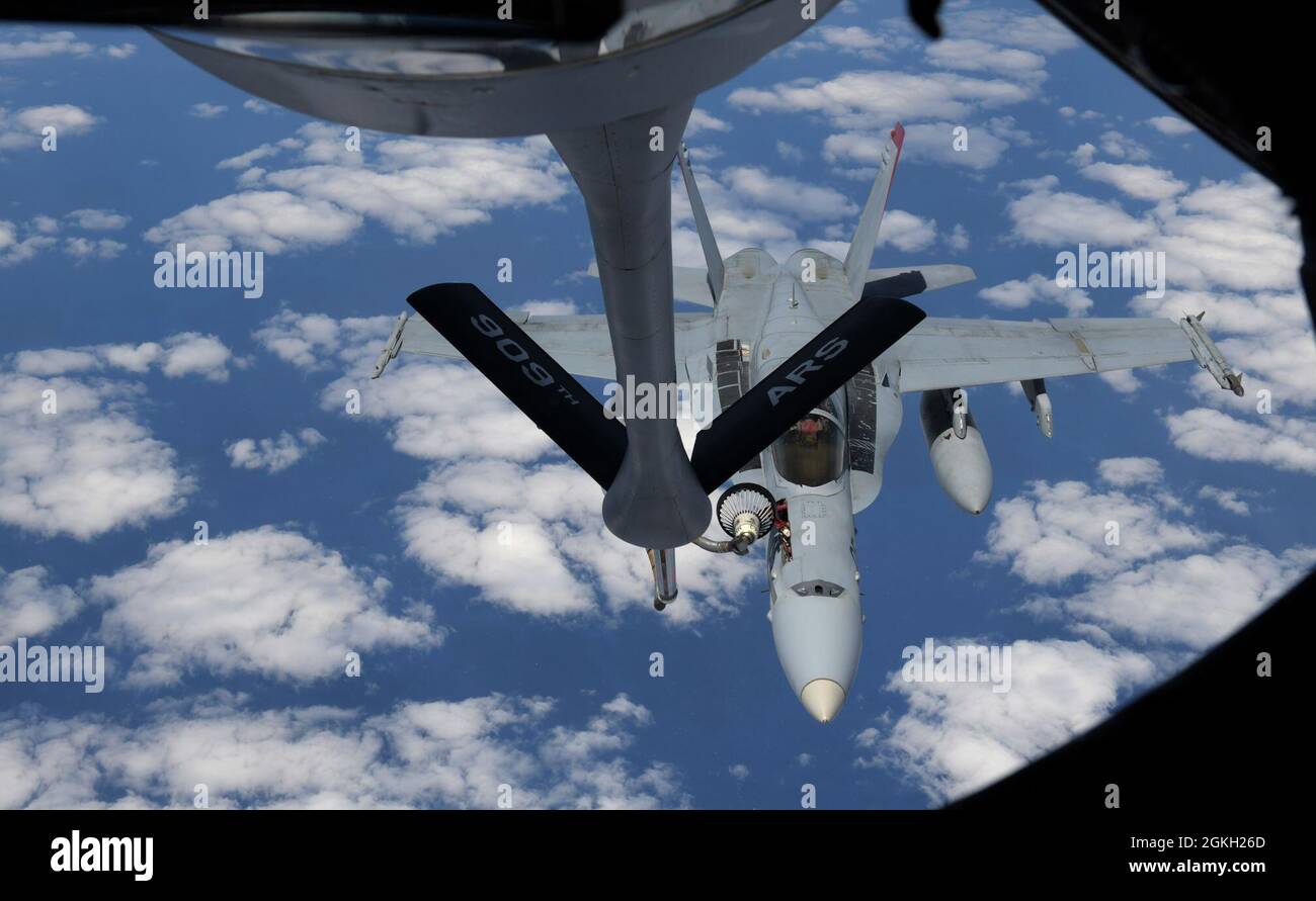 A U.S. Marine Corps F/A-18C Hornet aircraft from Marine Fighter Attack Squadron 232 out of Marine Corps Air Station Iwakuni, Japan, conducts aerial refueling with a 909th Air Refueling Squadron KC-135 Stratotanker from Kadena Air Base, Japan, over the Pacific Ocean, Apr. 20, 2021. The Air Force and Marine Corps frequently conduct joint training operations in the Pacific to maintain high standards of proficiency and continue to demonstrate our commitment to the U.S-Japan Treaty of Mutual Security and Cooperation. Stock Photo