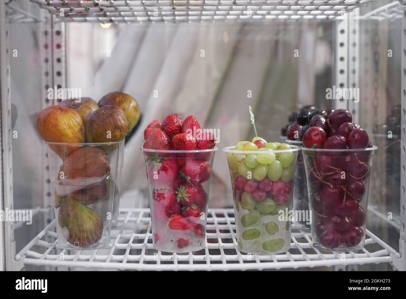 Cups with different fruits and berries in refrigerator Stock Photo Alamy