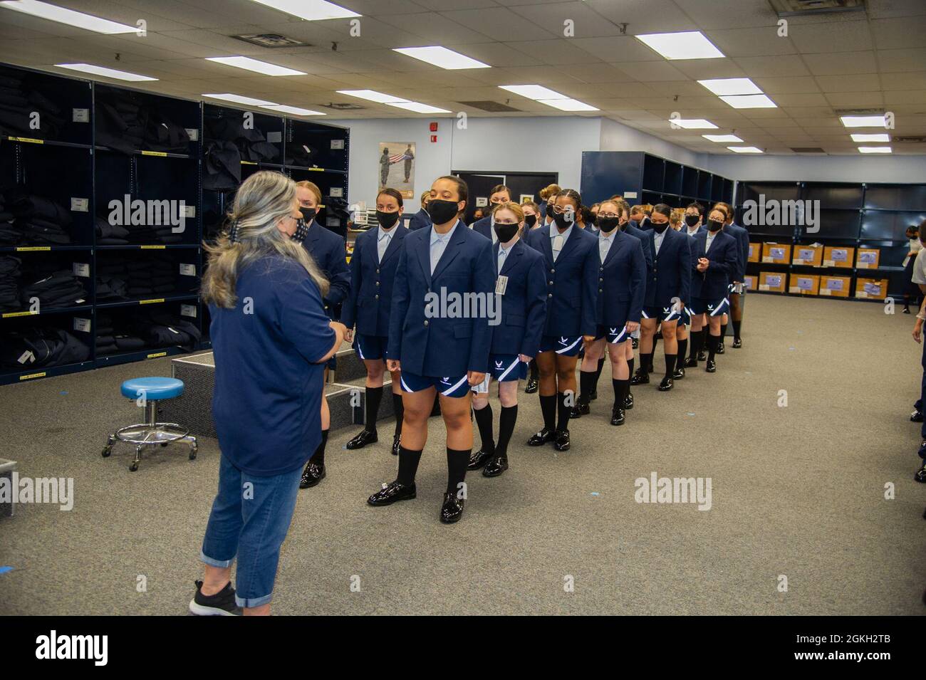 Military basic trainees receive their blues uniform during initial