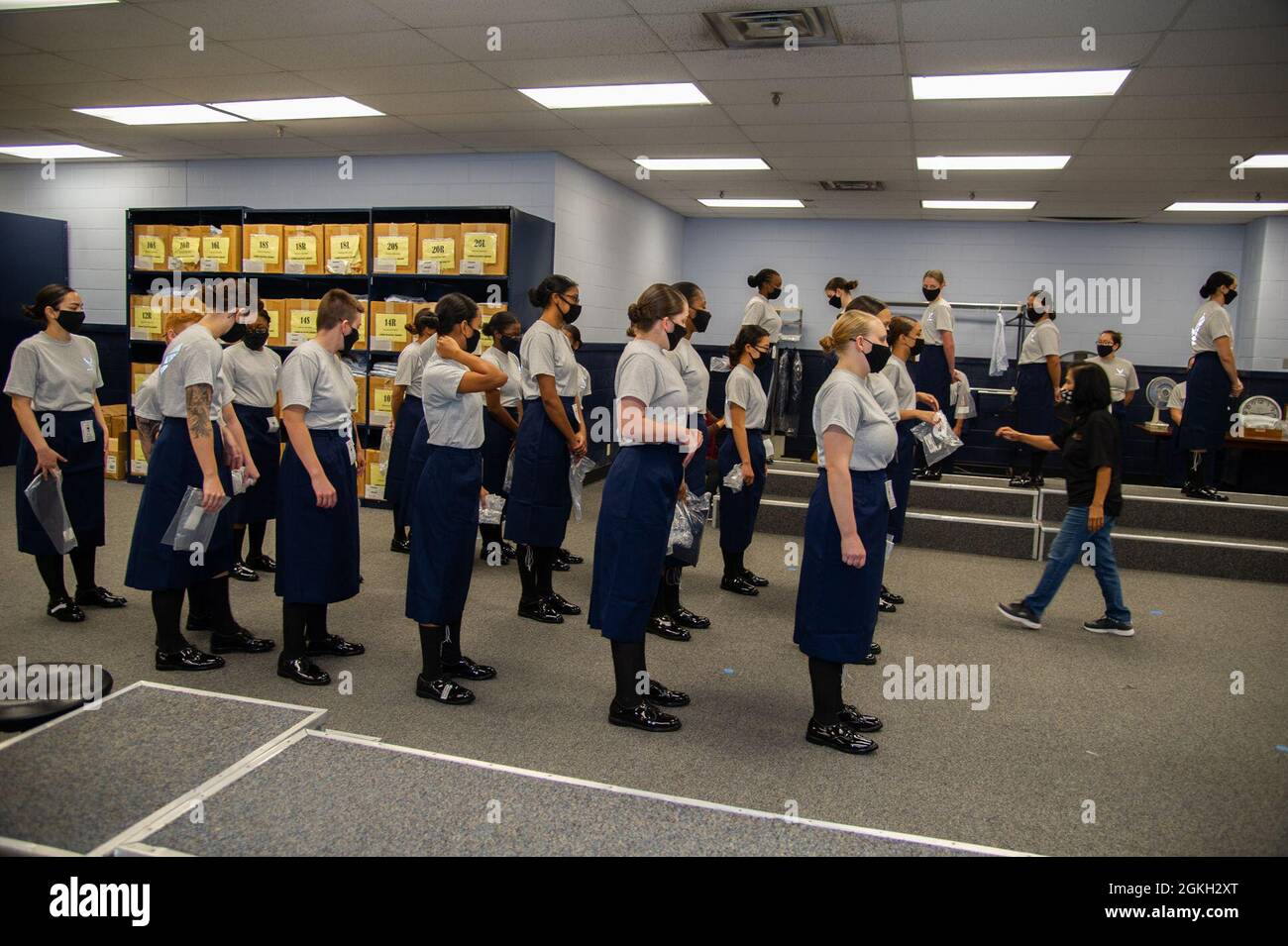 Military basic trainees receive their blues uniform during initial