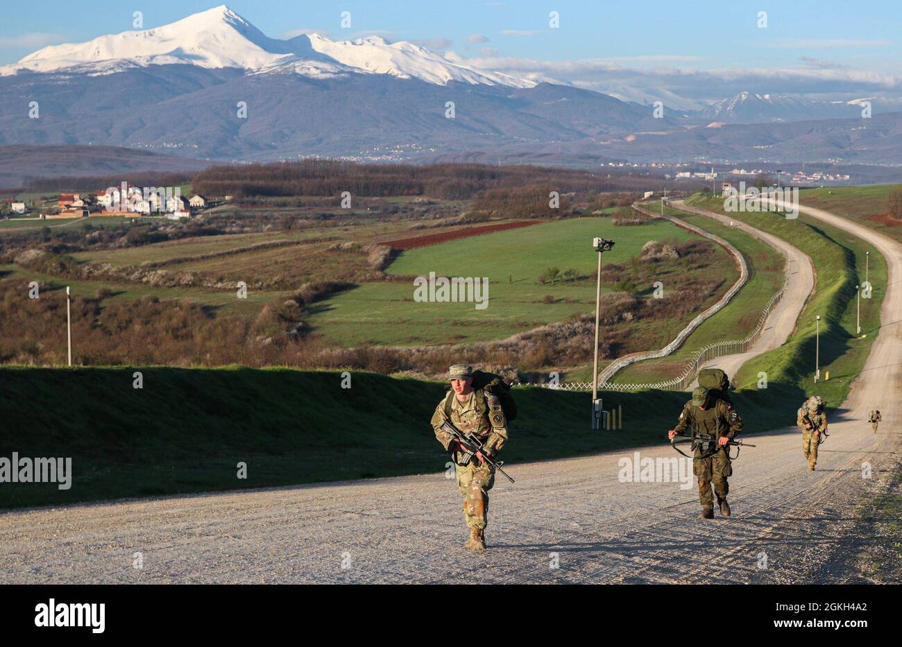 U.S. Soldiers conduct a six-mile ruck march during the RC-E Best Warrior Competition at Camp Bondsteel, Kosovo, on April 21, 2021. The ruck march came near the end of the two-day competition and tested the Soldiers’ endurance and determination. Stock Photo