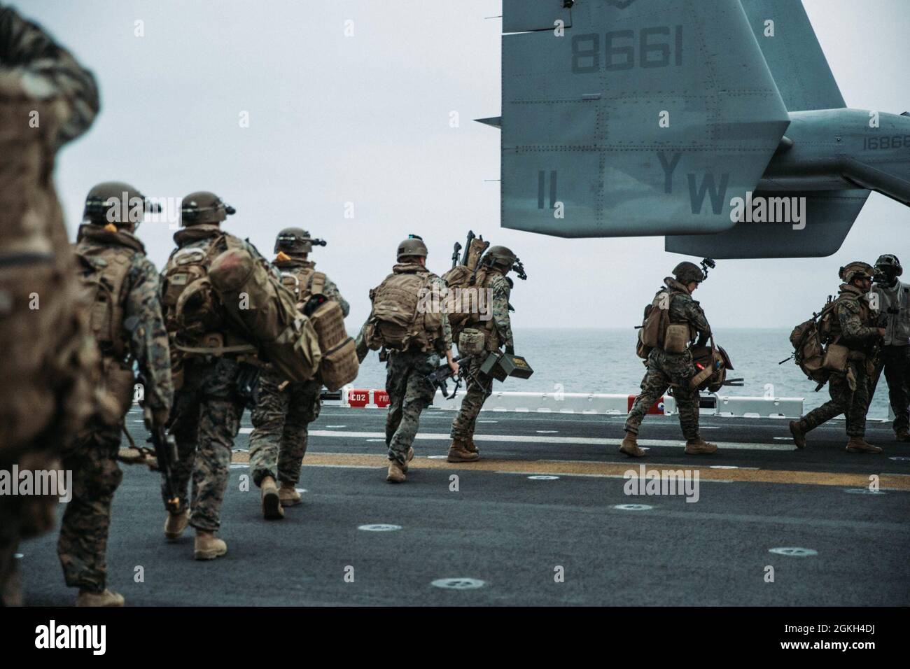 PACIFIC OCEAN (April 20, 2021) U.S. Marines with Bravo Company, Battalion Landing Team 1/1, 11th Marine Expeditionary Unit (MEU), load onto an MV-22B Osprey aboard amphibious assault ship USS Essex (LHD 2) during a tactical recovery of aircraft and personnel exercise, April 20. Sailors and Marines of the Essex Amphibious Ready Group (ARG) and the 11th MEU are conducting routine training off the coast of southern California. Together, the 11th MEU, Amphibious Squadron (PHIBRON) 1, and ships are designated as an ARG. Stock Photo