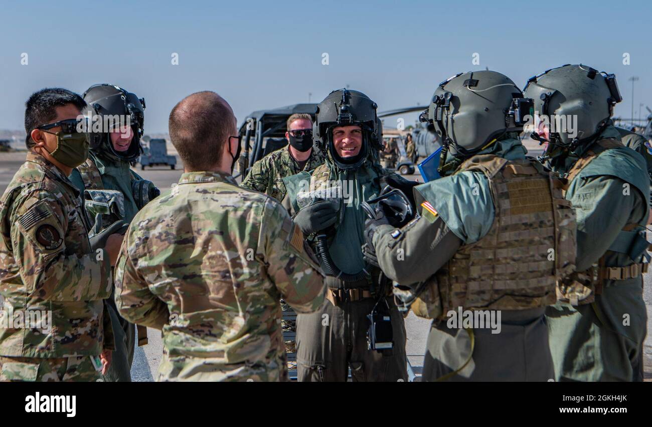 Representatives from across the Department of Defense and Airmen assigned to the 88th Test and Evaluation Squadron converse after a Chemical, Biological, Radiological, and Nuclear (CBRN) flight gear developmental test at Nellis Air Force Base, April 20, 2021. Along with the HH-60 Pave Hawk Helicopter, the representative aircraft for the test and evaluation phase of the new CBRN system will be the KC-135 Stratotanker, F-16 Fighting Falcon and C-130 Hercules aircraft. Stock Photo