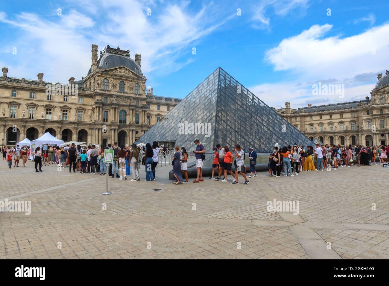 France, Paris, 2021-08-11. A long queue in front of the entrance of the Louvre museum in front of the pyramid because of the control of the health pas Stock Photo