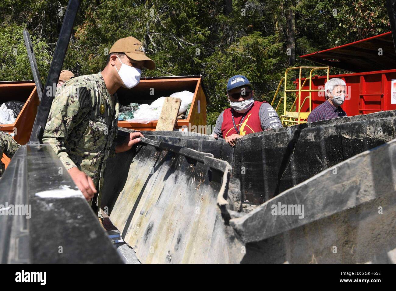 INDIAN ISLAND, Wash. (April 21, 2021) Master-at-Arms 2nd Class Marcus Wright, assigned to Naval Magazine Indian Island, left, and a civilian employee participate in a base cleanup in honor of the annual Earth Day celebration. Earth Day began in 1970 and continues to grow as a worldwide event, focused on promoting clean living and a healthy, sustainable habitat for people and wildlife. Stock Photo