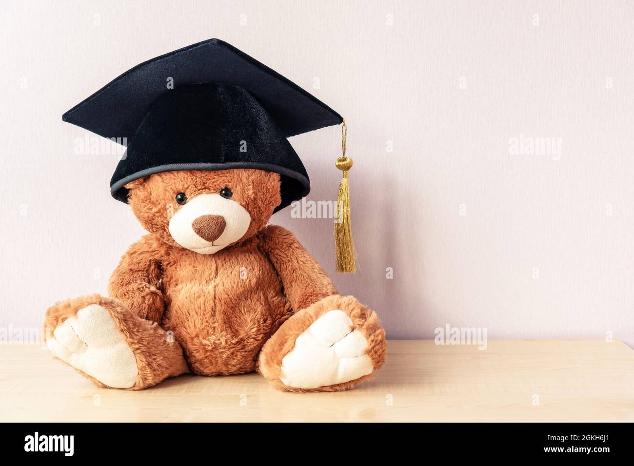 Adorable teddy bear sits on wooden table, copy space Stock Photo - Alamy
