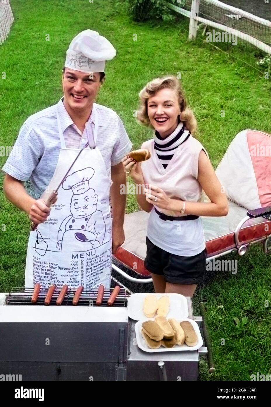 1950s 1960s COUPLE BACKYARD GRILLING LOOKING AT CAMERA COOKING HOT DOGS MAN WEARING APRON TOQUE & SKEWERED HOT DOG - c8205c DEB001 HARS BARBEQUE ACTIVE COOK PAIR BACKYARD RELATIONSHIP OLD TIME ROLL NOSTALGIA BARBECUE OLD FASHION 1 GRILL MENU WELCOME LAUGH VACATION SNACK LIFESTYLE CHAISE MARRIED SPOUSE HUSBANDS GROWNUP HOME LIFE COPY SPACE HALF-LENGTH LOUNGE AMERICANA FOODS SNACK FOODS B&W PARTNER EYE CONTACT SNACKS RECREATION CAMPING HOMEMAKER ACTIVITY GRILLING HAPPINESS HOMEMAKERS LEISURE PREPARE SNACK FOOD FRANKFURTER QUALITY TIME RECREATION FEMININE QUALITY BUN FRANK WIENER LOUNGE CHAIR Stock Photo