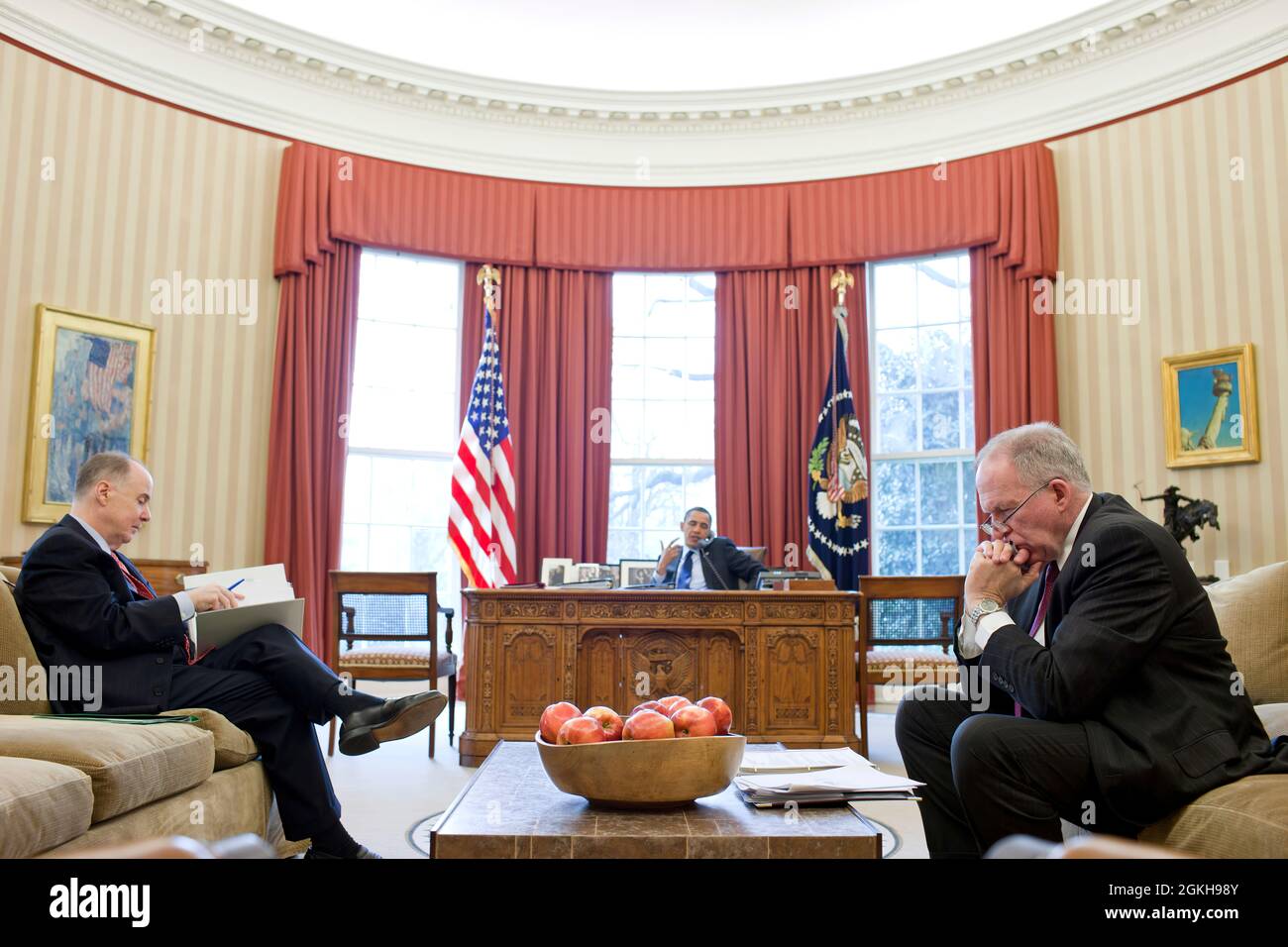 National Security Advisor Tom Donilon and John Brennan, Assistant to the President for Homeland Security and Counterterrorism, right, listen as President Barack Obama talks on the phone in the Oval Office, March 16, 2011. (Official White House Photo by Pete Souza) This official White House photograph is being made available only for publication by news organizations and/or for personal use printing by the subject(s) of the photograph. The photograph may not be manipulated in any way and may not be used in commercial or political materials, advertisements, emails, products, promotions that in a Stock Photo