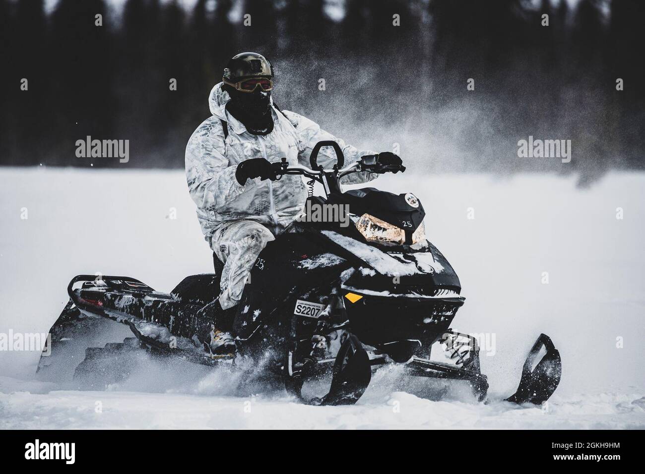 TALKEETNA, Alaska- A Green Beret with 1st Battalion, 1st Special Forces Group (Airborne), maneuvers through the Arctic tundra on a snowmobile April 2021, during an Arctic Mobility Training. The Arctic has recently developed into an international competition space and potential future battlefield that 1st SFG (A) Soldiers will have to continue to familiarize themselves with. Stock Photo