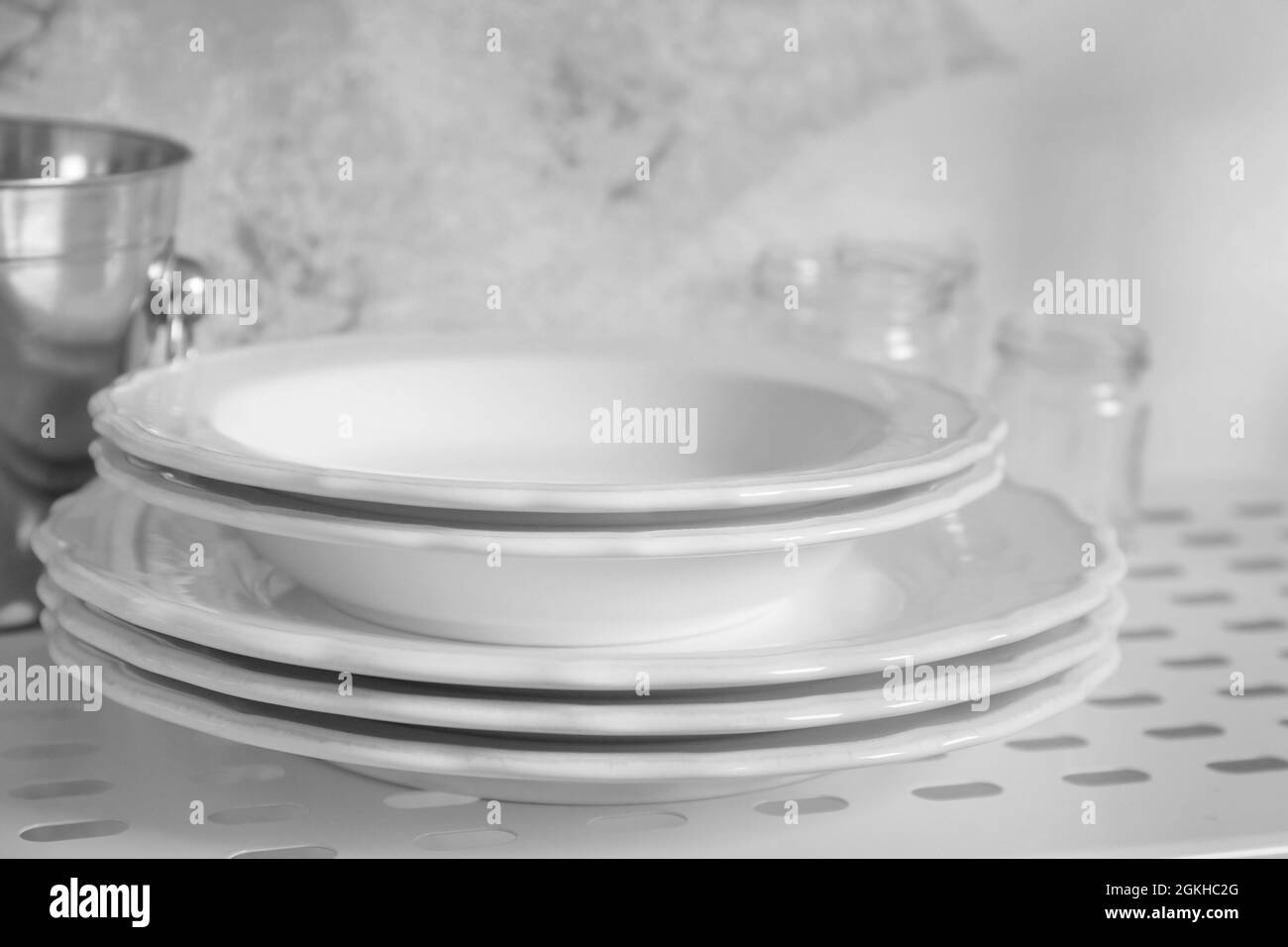 White plates on shelf of storage stand Stock Photo Alamy