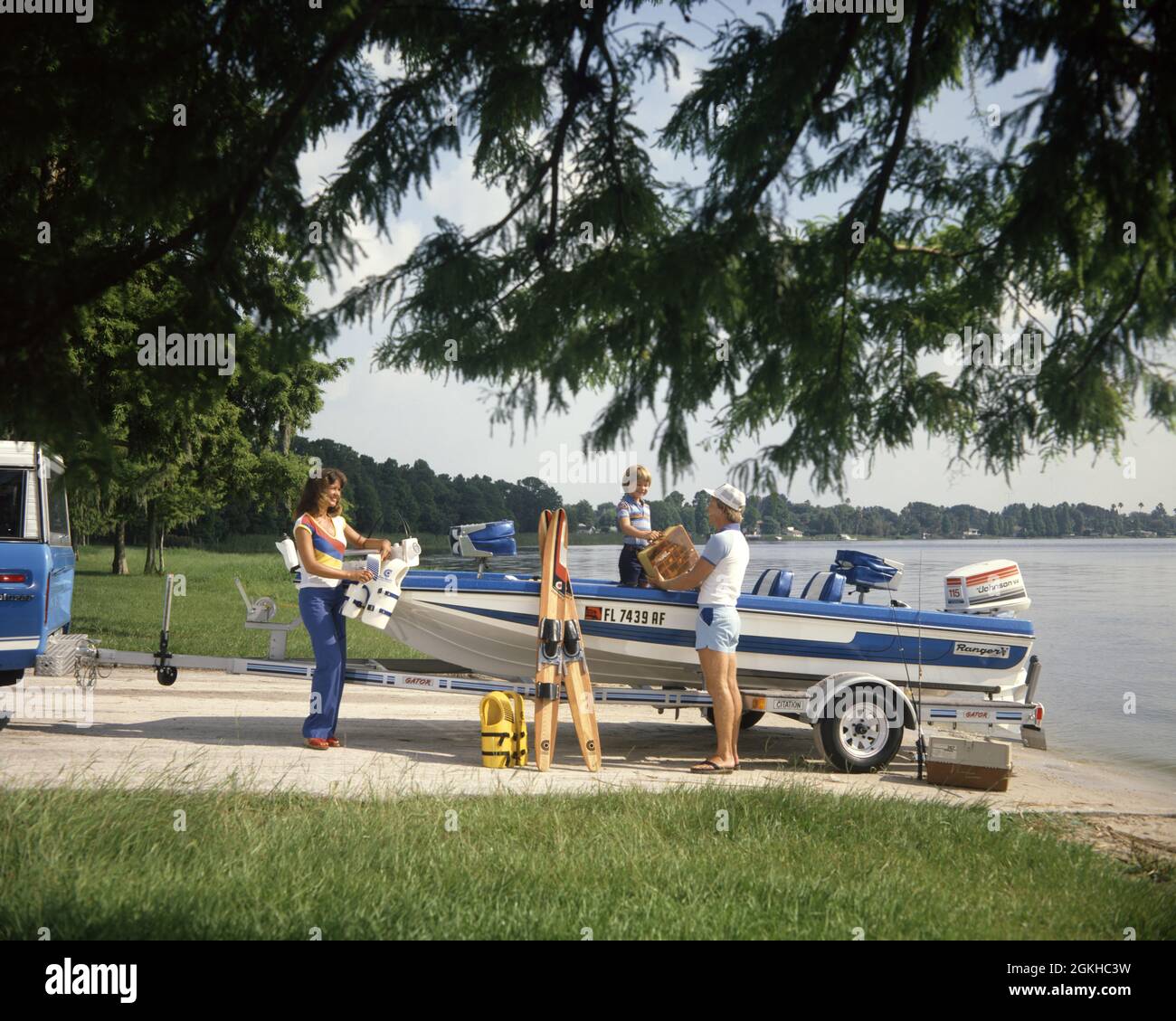 1980s FAMILY ON VACATION PREPARING TO PUT OUTBOARD MOTOR BOAT TOWED BEHIND  PICKUP TRUCK INTO LAKE WATER - kb15891 CYP001 HARS NOSTALGIC PAIR COLOR  MOTHERS OLD TIME FIGURES NOSTALGIA TRAILER OLD FASHION