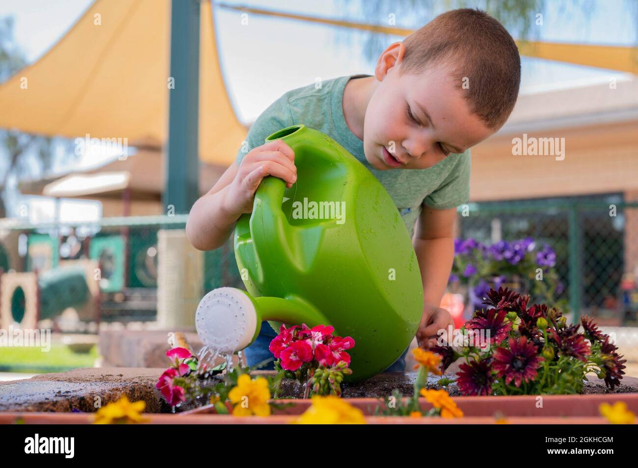 Daniel Morgan, Child Development Center (CDC) preschooler, waters plants at Nellis Air Force Base, Nevada, April 22, 2021. The CDC provided children the opportunity to plant many different flowers in celebration of Earth Day. Stock Photo