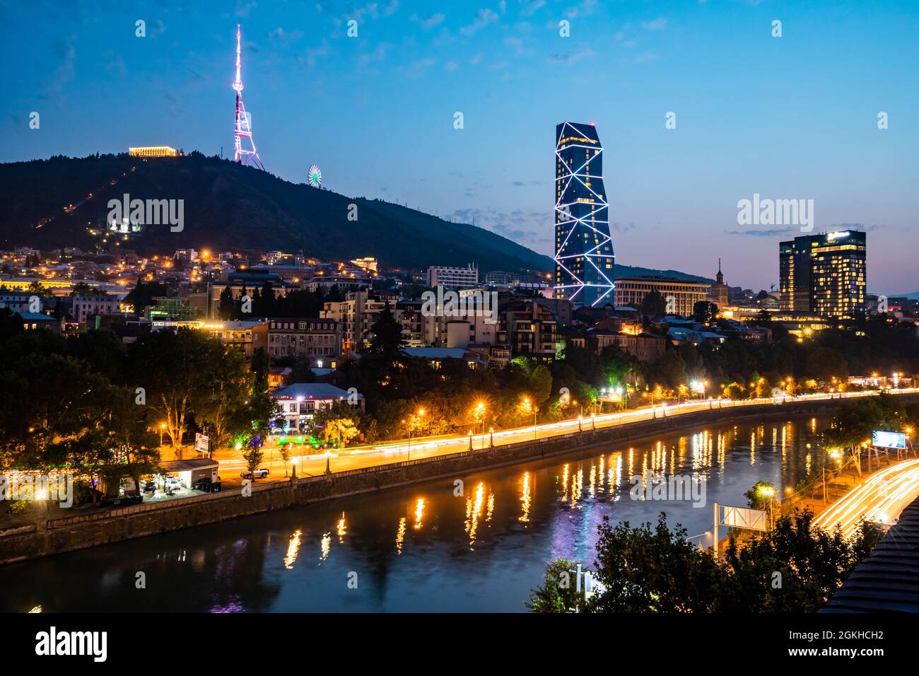 Colorful view of illuminated Mtkvari river in Tbilisi Georgia at night from above Stock Photo