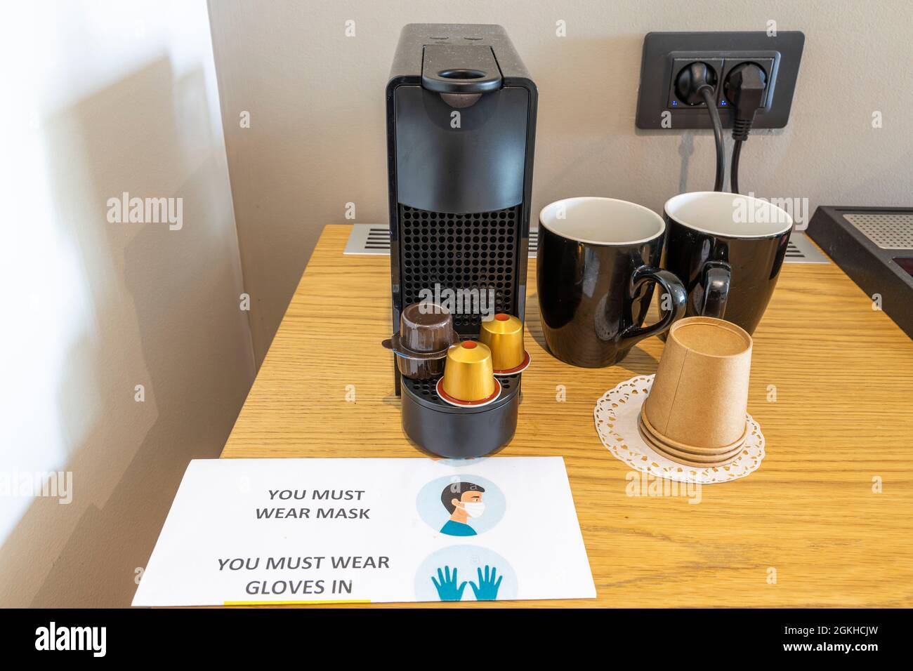 Click up view of coffee capsule machine and two cups on wooden table in  hotel room. Greece Stock Photo - Alamy