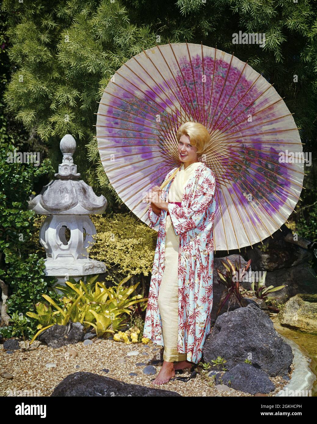 1960s BLONDE WOMAN BOUFFANT HAIRDO STANDING UNDER LARGE PINK PAINTED UMBRELLA SUNNY JAPANESE GARDEN WEAR KIMONO PRINTED ROBE - kg3465 CYP001 HARS ROBE GROWNUP LUXURY FULL-LENGTH PERSONS GROWN-UP CHARACTER SUNNY THEME KIMONO BAMBOO LEISURE ORIENTAL STYLES PAINTED STYLISH ANONYMOUS FASHIONS HAIRDO PEOPLE ADULTS YOUNG ADULT WOMAN BOUFFANT CAUCASIAN ETHNICITY EXOTIC HANDMADE OLD FASHIONED PRINTED Stock Photo
