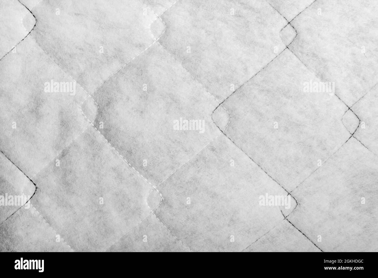Texture backdrop photo of white colored sintepon fibers material with stitching pattern. Stock Photo