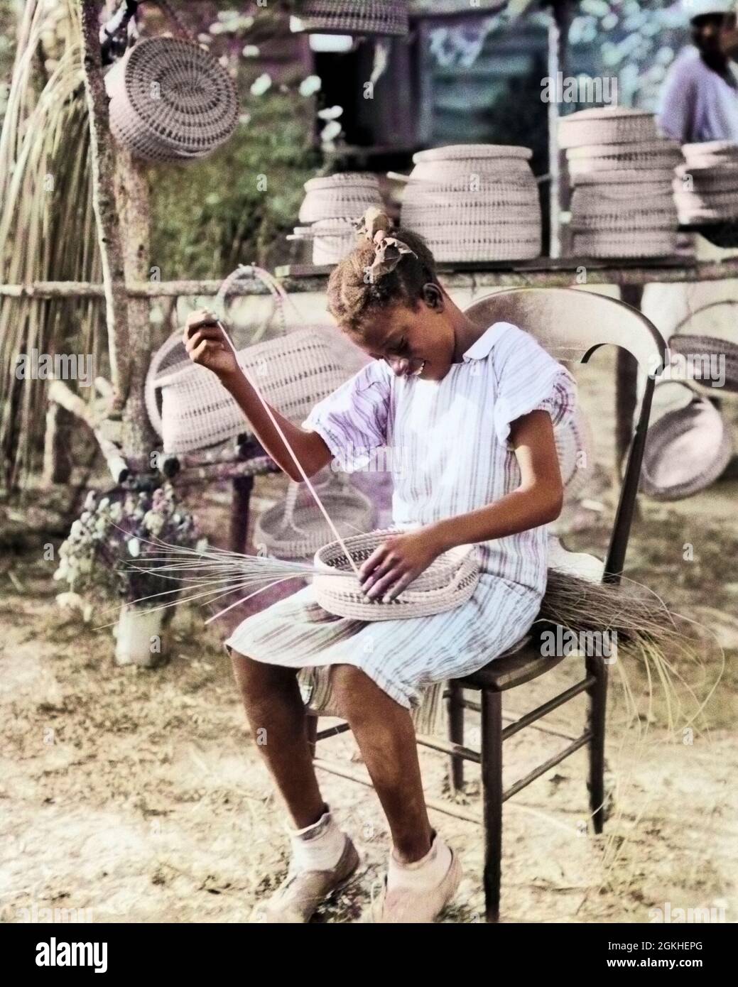 1930s 1940s ANONYMOUS SMILING YOUNG AFRICAN-AMERICAN GULLAH GIRL WEAVING MAKING BASKET FROM SWEETGRASS SOUTH CAROLINA USA - n1204c HAR001 HARS 1 JUVENILE LIFESTYLE CELEBRATION FEMALES JOBS RURAL HEALTHINESS HOME LIFE UNITED STATES COPY SPACE FULL-LENGTH HIGHWAY PERSONS INSPIRATION TRADITIONAL UNITED STATES OF AMERICA TEENAGE GIRL CRAFT SPIRITUALITY CONFIDENCE SADNESS NORTH AMERICA NORTH AMERICAN SKILL OCCUPATION HAPPINESS SKILLS LANGUAGE WELLNESS STRENGTH CUSTOMER SERVICE AFRICAN-AMERICANS AFRICAN-AMERICAN KNOWLEDGE TOURIST BLACK ETHNICITY LABOR PRIDE OPPORTUNITY ATTRACTION AUTHORITY Stock Photo