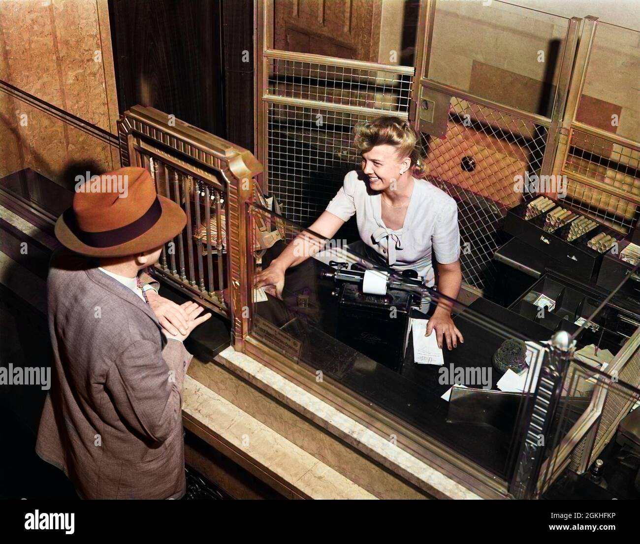 1940s SMILING WOMAN BANK TELLER BEHIND CAGE SERVING MALE CUSTOMER - q44258c CPC001 HARS SERVE BILL PLEASED JOY CLERK FEMALES CURRENCY CHANGE LADIES PERSONS BANKING MALES CLIENT CAGE OCCUPATION SAVE PAYCHECK HEAD AND SHOULDERS CHEERFUL HIGH ANGLE CUSTOMER SERVICE PAY WORKFORCE LABOR OCCUPATIONS PAYMENT SMILES JOYFUL MID-ADULT WOMAN CAUCASIAN ETHNICITY OLD FASHIONED Stock Photo