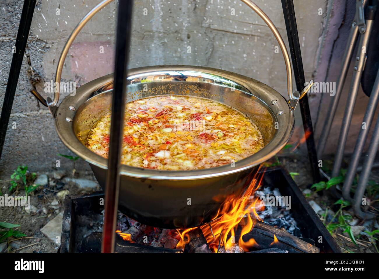 Pot with vegetables cauldron over open fire, preparing stew soup on wood  grill, outdoor cooking Stock Photo - Alamy