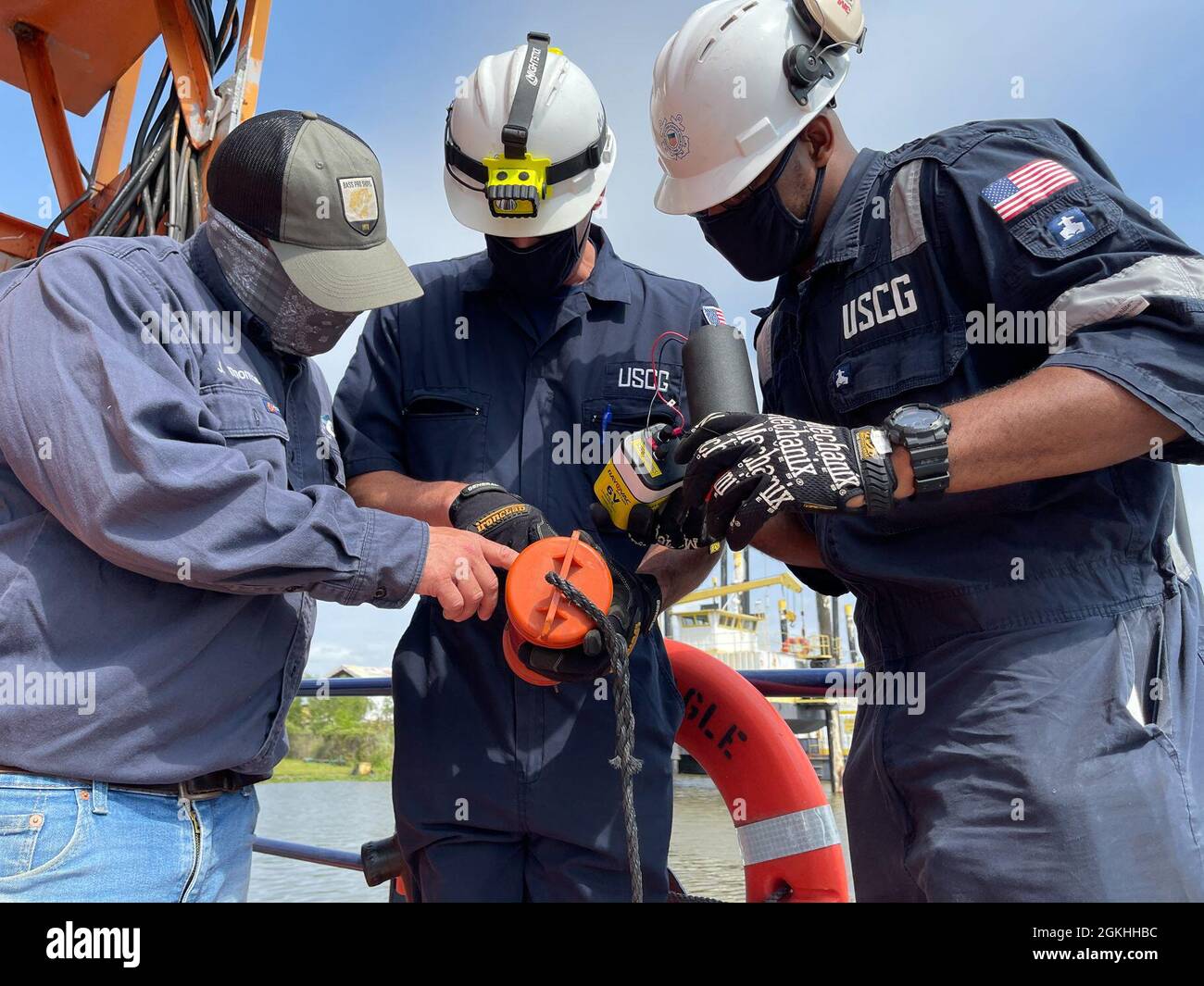 Coast Guard Marine Inspectors and a SEACOR Eagle crew member verify the battery in a life ring light during an inspection in Houma, Louisiana, April 23, 2021. The crew and vessel was inspected by Coast Guard marine inspectors for readiness and approval to be used as an asset for the SEACOR Power response. Stock Photo
