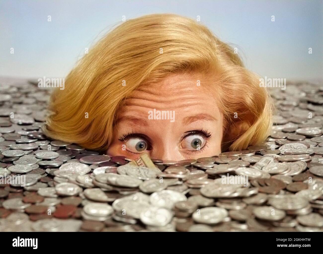 1960s BUG-EYED SURPRISED WOMAN BURIED IN COINS MONEY SYMBOLIC - s15481c HAR001 HARS BUG-EYED OVERWHELMED SURROUNDED WEALTH OVERWHELM INUNDATED CONCEPTUAL INUNDATION INUNDATE SYMBOLIC OVERWHELMING YOUNG ADULT WOMAN BLACK AND WHITE CAUCASIAN ETHNICITY HAR001 OLD FASHIONED Stock Photo