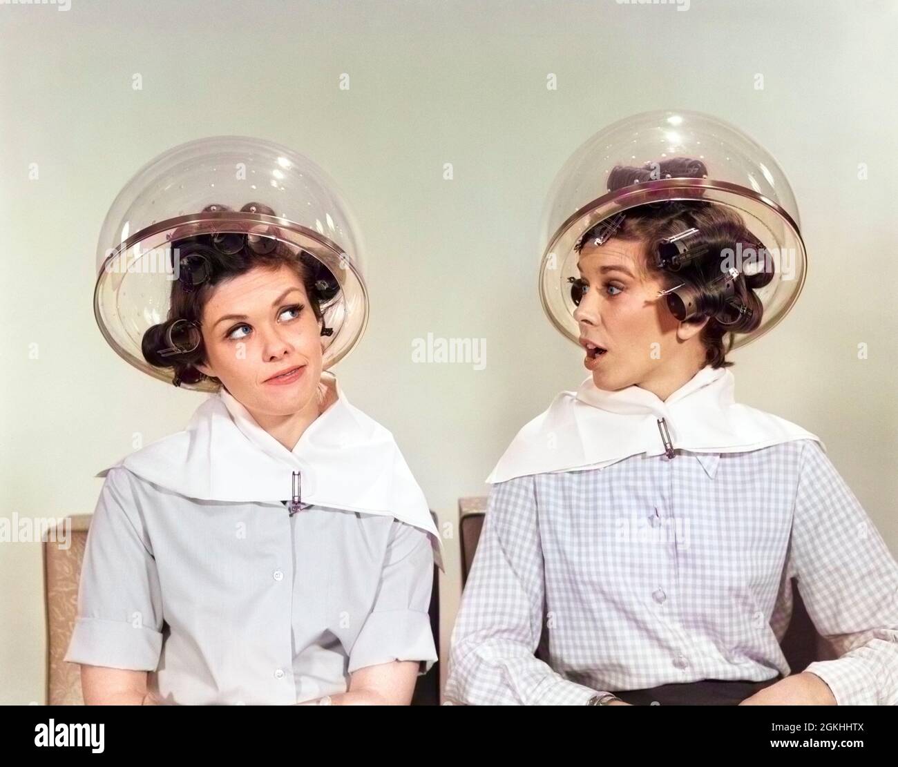 1960s TWO WOMEN SITTING UNDER SALON HAIRDRYERS GOSSIPING TALKING - s15087c HAR001 HARS FRIEND YOUNG ADULT SALON INFORMATION HOOD LIFESTYLE GROWNUPS FEMALES GOSSIP HEAT GROWNUP COPY SPACE FRIENDSHIP HALF-LENGTH LADIES PERSONS GROWN-UP SPEAK PAIRS SIBLINGS SISTERS GOSSIPING B&W CURLERS HAPPINESS LEISURE NETWORKING SIBLING SMILES GOSSIPS DRYERS HAIR DRYER BEAUTY PARLOR RUMOR STYLISH PLASTIC DOME HAIR SALON HAIRDRYERS MID-ADULT MID-ADULT WOMAN RUMORS YOUNG ADULT WOMAN BLACK AND WHITE CAUCASIAN ETHNICITY HAR001 OLD FASHIONED Stock Photo