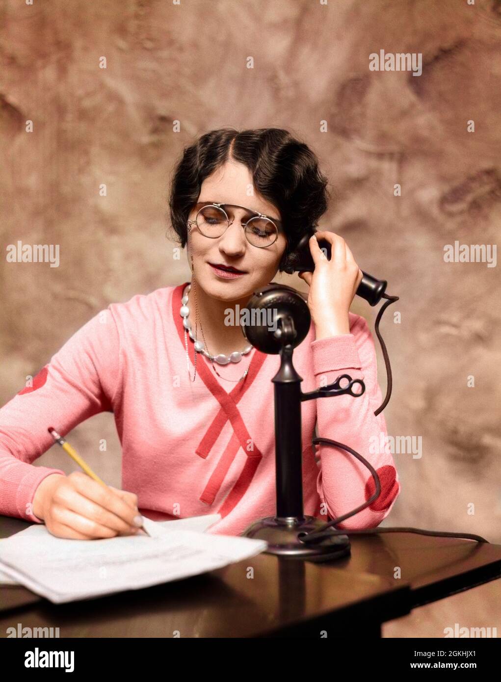 1920s WOMAN WEARING PINCE-NEZ GLASSES SITTING AT DESK TALKING ON CANDLESTICK PHONE AND WRITING - t2265c HAR001 HARS LISTEN FEMALES VERTICAL GROWNUP HOME LIFE COMMUNICATING SPEAK WRITE CHAT CANDLESTICK WOMAN'S RELEASES OFFICES OPTICAL TELEPHONING CHATTER CUSTOMER SERVICE WOMAN'S LIBERATION WOMEN'S RIGHTS LIB PENCILS WOMAN'S RIGHTS WOMEN'S LIB WOMEN'S LIBERATION CANDLESTICK PHONE RIGHTS PINCE-NEZ OCCUPATIONS OFFICE MACHINE PHONES CONNECTION TELEPHONES PHONING SECRETARIES STYLISH WRITER LIBERATION WOMEN'S ADMINISTER COMMUNICATE MID-ADULT MID-ADULT WOMAN YOUNG ADULT WOMAN CAUCASIAN ETHNICITY Stock Photo