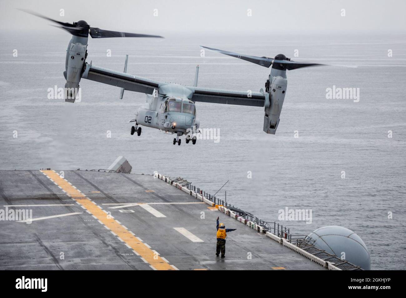 210424-N-MZ836-3169 ATLANTIC OCEAN (April 24, 2021) Aviation Boatswain's Mate (Handling) 3rd Class Ethan Pendergrass directs an MV-22 Osprey assigned to Marine Medium Tiltrotor Squadron 263 during flight operations aboard the Wasp-class amphibious assault ship USS Kearsarge (LHD 3) April 24, 2021. Kearsarge, homeported at Naval Station Norfolk, is underway to certify for operations at sea. Stock Photo
