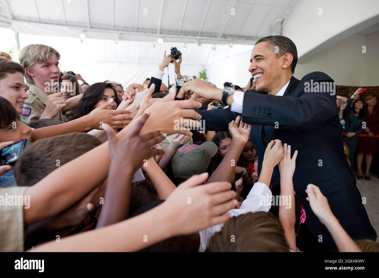 President Barack Obama greets young people during a visit to the U.S. Ambassador's residence in San Salvador, El Salvador, March 23, 2011. (Official White House Photo by Pete Souza) This official White House photograph is being made available only for publication by news organizations and/or for personal use printing by the subject(s) of the photograph. The photograph may not be manipulated in any way and may not be used in commercial or political materials, advertisements, emails, products, promotions that in any way suggests approval or endorsement of the President, the First Family, or the Stock Photo