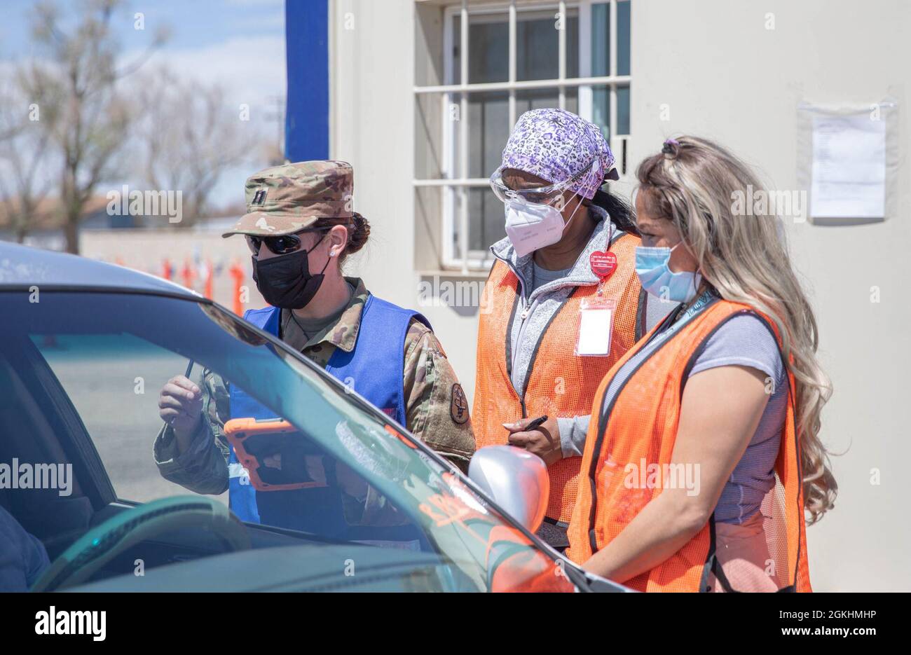 U.S. Army Capt. Meredith Myatt, left, a registered nurse assigned to Andrew Rader Health Clinic, and Carol Abbott, middle, a civilian registered nurse, speak with a member of the Pueblo community while Louisa Carlos, right, a Spanish translator with the Federal Emergency Management Agency (FEMA), translates at the Community Vaccination Center at the Colorado State Fairgrounds in Pueblo, Colorado, April 25, 2021. The Soldiers at the Pueblo Community vaccination site work side by side with their civilian counterparts to help community members. U.S. Northern Command, through U.S. Army North, rema Stock Photo
