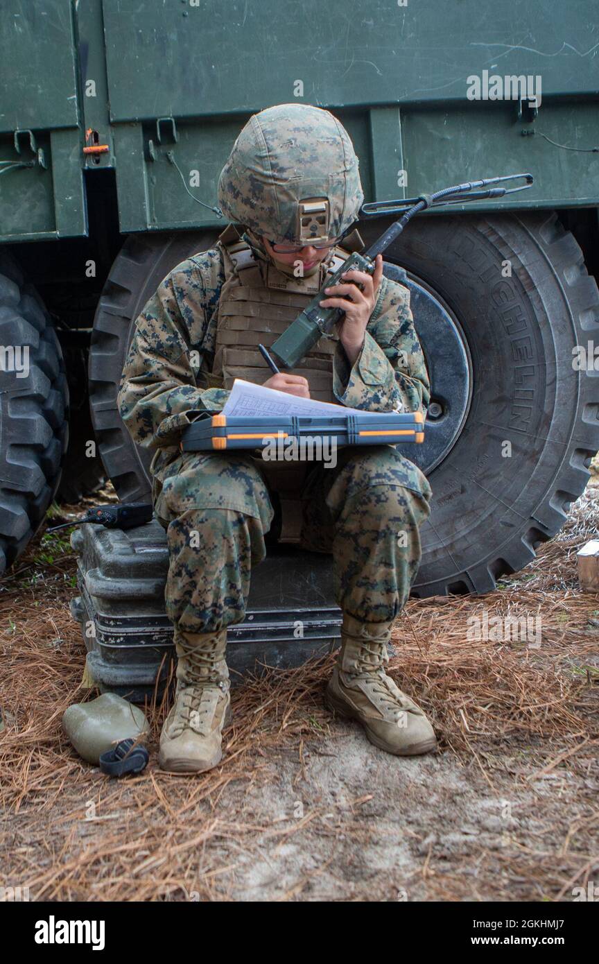 U.S. Marine Corps Lance Cpl. Khamryn Cruz, a native of Talofofo, Guam, and a field artillery cannoneer with 1st Battalion, 10th Marine Regiment, 2d Marine Division (2d MARDIV), confirm a fire mission over radio during Exercise Rolling Thunder 21.2 on Fort Bragg, N.C, April 25, 2021. This exercise is a 10th Marine Regiment-led live-fire artillery event that tests 10th Marines' abilities to operate in a simulated littoral environment against a peer threat in a dynamic and multi-domain scenario. Stock Photo