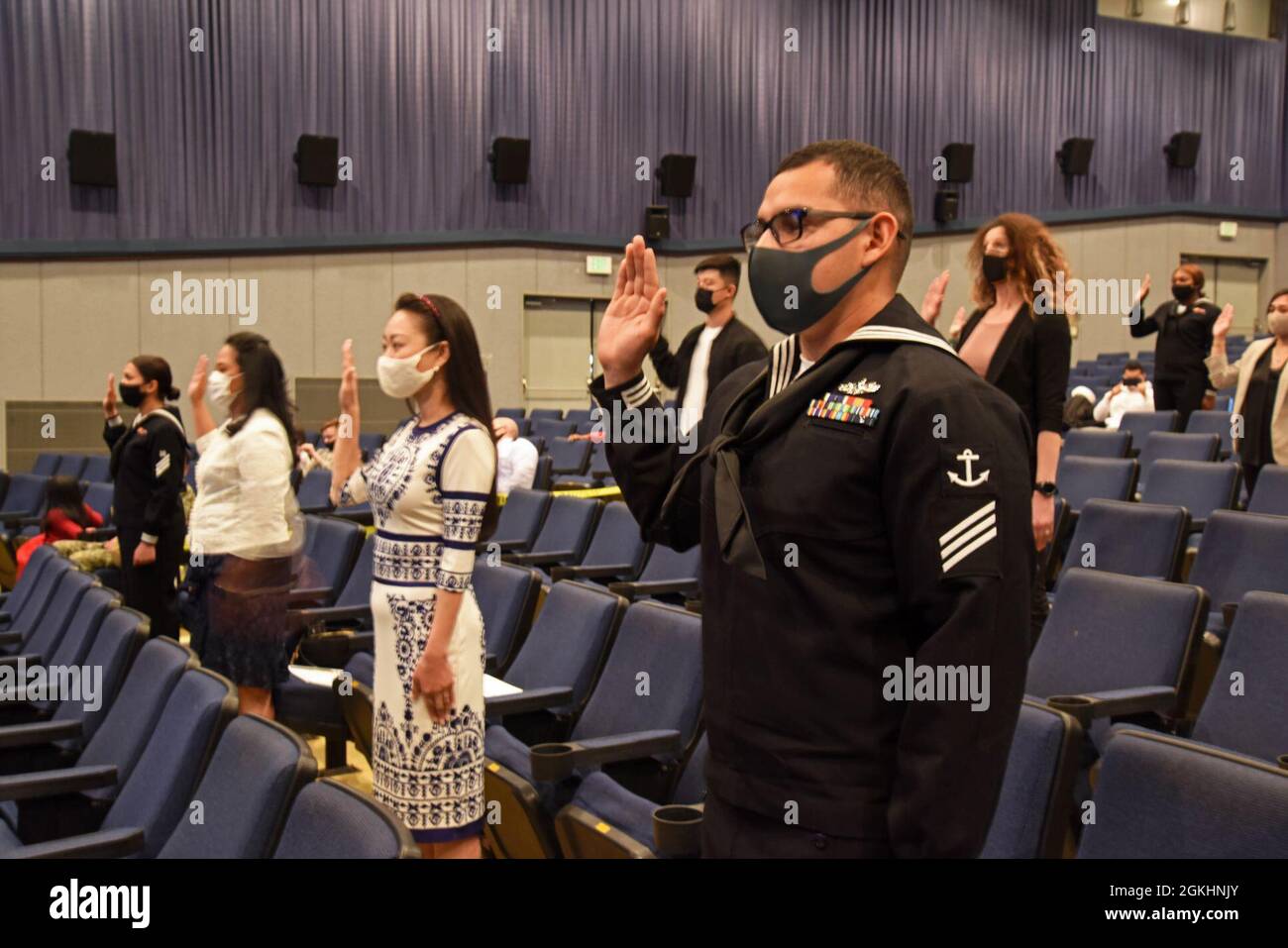 210426-N-HR587-1021  YOKOSUKA, Japan (April 26, 2021) — Seaman Armando Diaz-Mejia, right, civilians and fellow Sailors onboard Commander, Fleet Activities Yokosuka (CFAY) recite the Oath of Allegiance during a United States Citizenship and Immigration Services Stock Photo