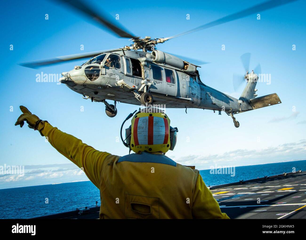 210426-N-DA693-1075  PACIFIC OCEAN (Apr. 26, 2021) Aviation Boatswain’s Mate (Handling) 2nd Class Keifer Galbraith, an enlisted landing signalman assigned to the Military Treatment Facility embarked aboard Military Sealift Command hospital ship USNS Mercy (T-AH 19), marshals an MH-60S Seahawk assigned to Air Test and Evaluation (HX) Squadron 21 of Naval Air Station (NAS) Patuxent River, Md., to depart from the ship’s flight deck Apr. 26. Mercy is underway off the coast of Southern California completing Dynamic Interface Testing, where the ship’s aviation facilities will be evaluated for compat Stock Photo