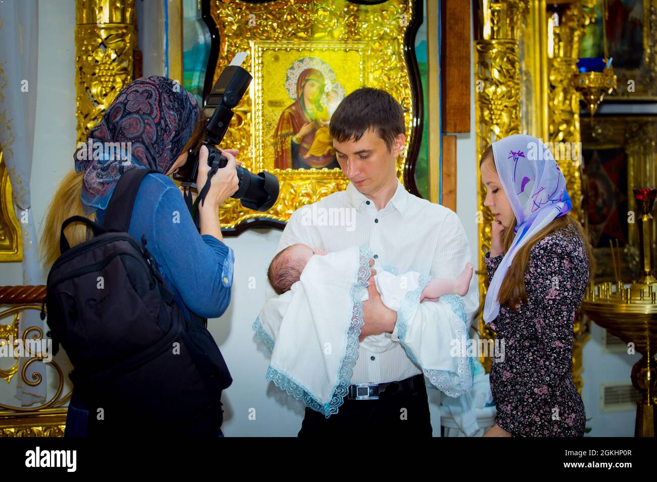 Dnepropetrovsk, Ukraine - 05.23.2015: A beautiful woman photographer is doing her job. Baptism of a child in a church. Stock Photo