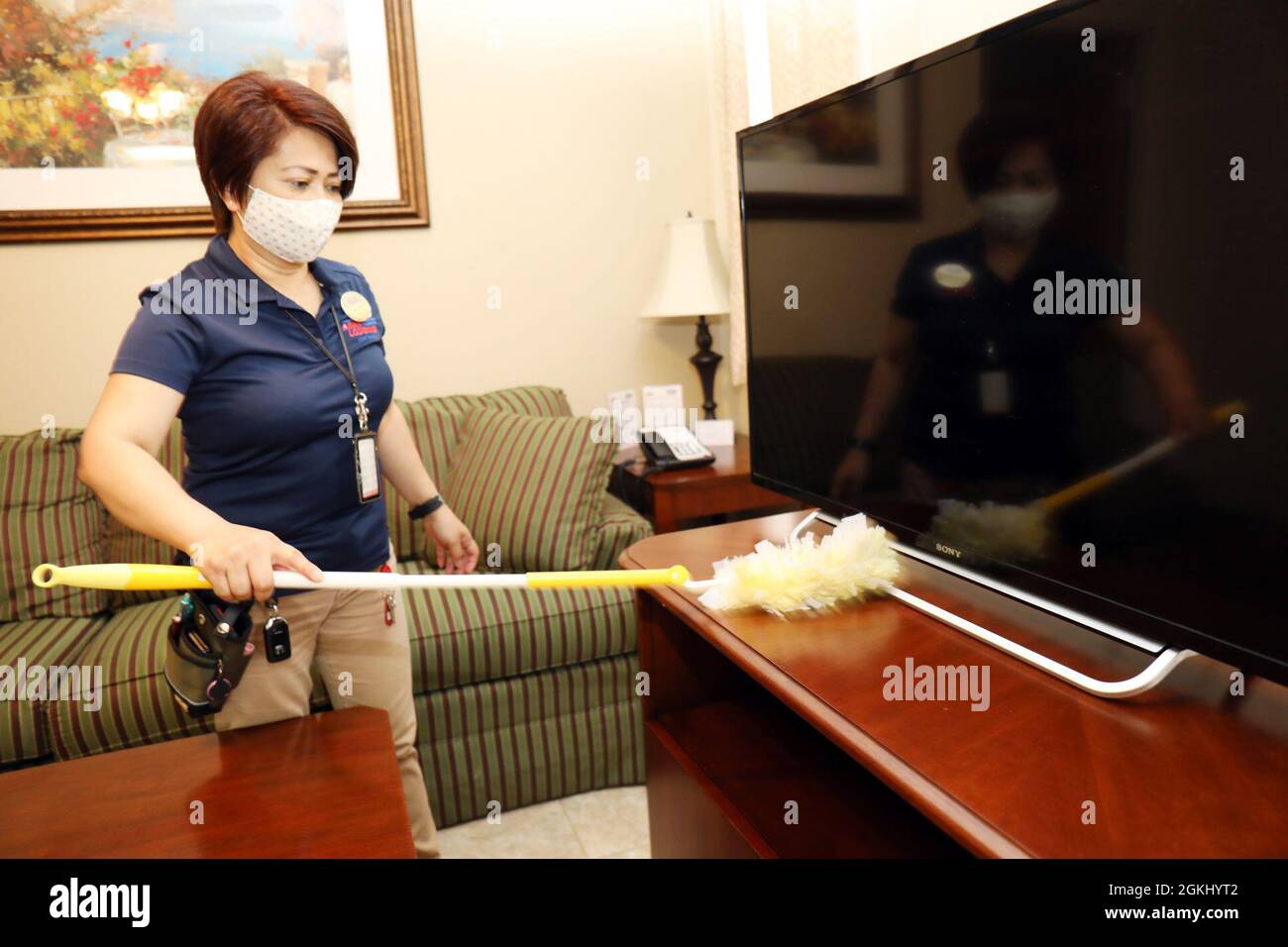 Maria Devera, housekeeping leader, prepares a room for new guests at