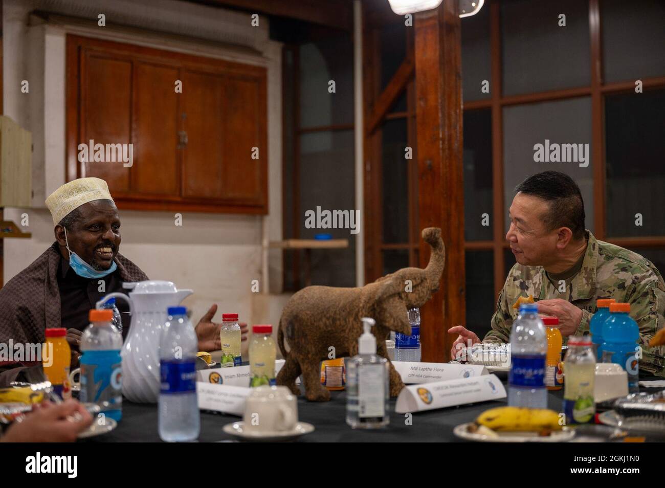 Hassan Ahmed Migane, Djiboutian Imam (left), enjoys the company of U.S. Army Maj. Gen. Lapthe C. Flora (right), commanding general, Combined Joint Task Force- Horn of Africa during an Iftar to celebrate the end of Ramadan in Djibouti, April 28, 2021. The Iftar event provided an opportunity for key partners to come together in unity, build on existing relationships, and reaffirm the importance of cross-cultural understanding. Stock Photo