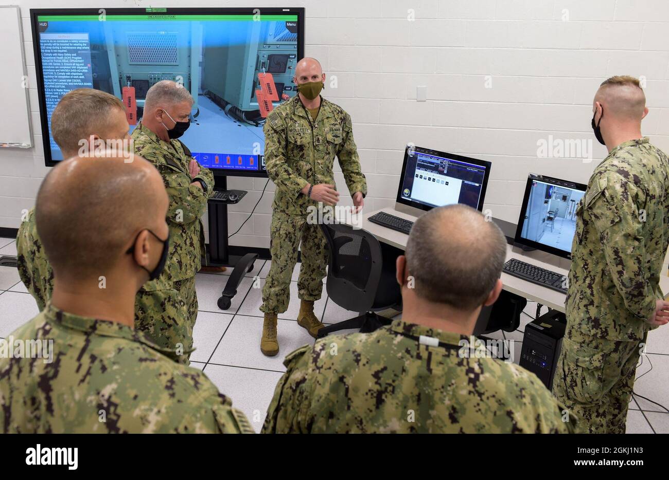 210428-N-KJ380-1056 PENSACOLA, Fla. (April 28, 2021) - Chief of Naval Personnel Vice Adm. John B. Nowell Jr. (2nd from left)  participates in a Multipurpose Reconfigurable Training System 3D® (MRTS 3D®) technology training device demonstration and discussion with staff at the Center for Information Warfare Training and Information Warfare Training Command (IWTC) Corry Station. Nowell, along with Fleet Master Chief Wes Koshoffer, visited for a familiarization brief and tour of CIWT and IWTC Corry Station onboard Naval Air Station Pensacola Corry Station, Pensacola, Florida. The visit offered an Stock Photo