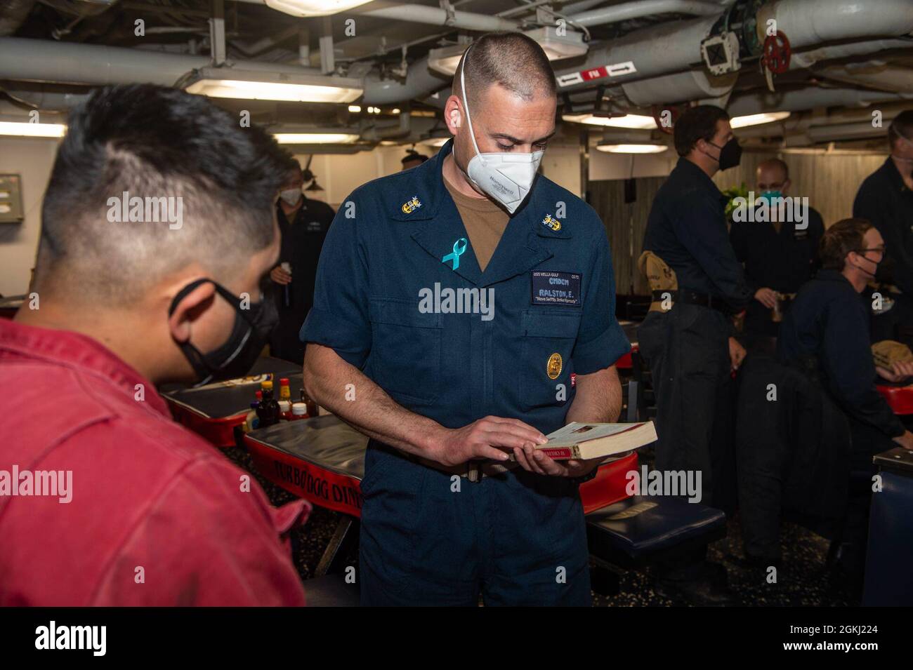 210427-N-RG587-2018 ATLANTIC OCEAN (April 27, 2021) CMDCM Eric Ralston, from Northglenn Colorado, command master chief of the Ticonderoga-class guided-missile cruiser USS Vella Gulf (CG 72), observes Holocaust literature during a Holocaust remembrance ceremony April 27, 2021. Vella Gulf is operating with the IKE Carrier Strike Group on a routine deployment in the U.S. Sixth Fleet area of operations in support of U.S. national interests and security in Europe and Africa. Stock Photo