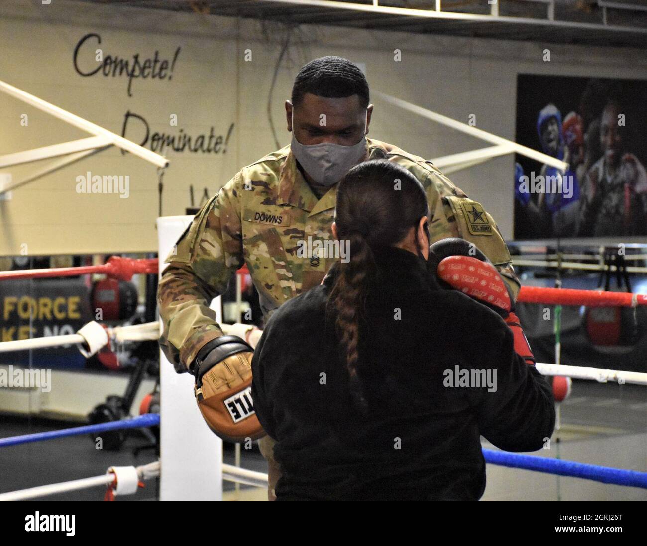 Erika Torres, social media specialist, Phoenix Recruiting Battalion, engages Sgt. 1st Class Christopher Downs, head boxing coach, World Class Athlete Program, with training punches during a demonstration with the Army Boxing World Class Athlete team, April 28, Fort Carson, Colo. Stock Photo