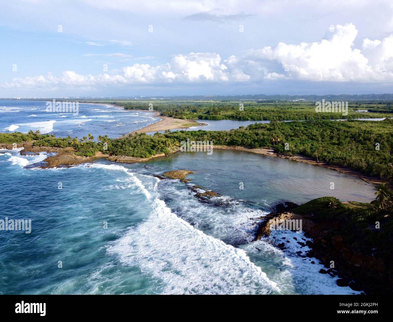 Landscape of the sea surrounded by greenery under a cloudy sky Stock ...