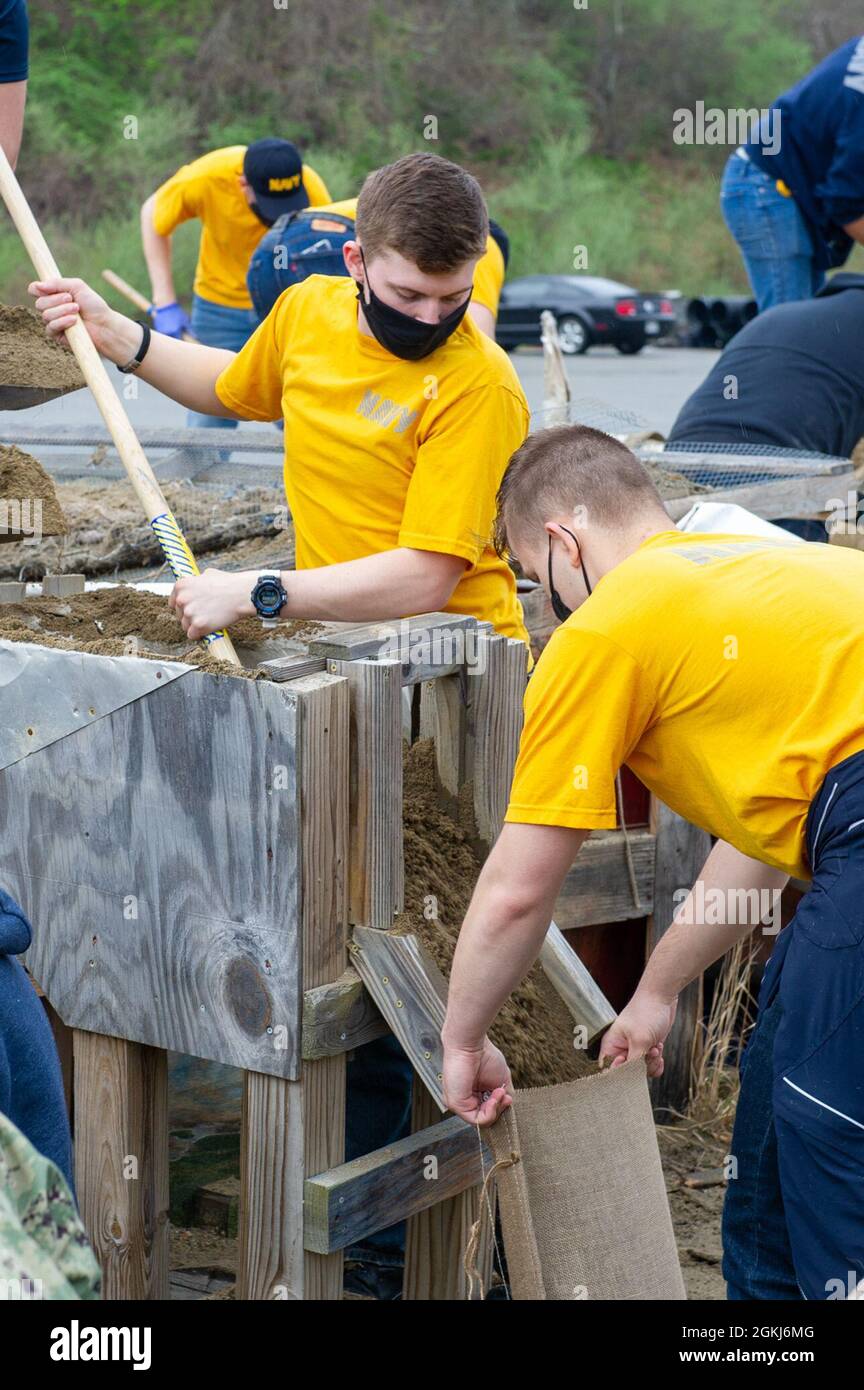 210429-N-EJ843-0046 GROTON, Conn. (April 28, 2021) Students from the Naval Submarine School (SUBSCOL) fill up sandbags onboard Naval Submarine Base (SUBASE) New London. “Teamwork makes the dream work,” said Chief Engineman Bradley Bruns, First Lieutenant Department leading chief petty officer. SUBSCOL was one of many commands to help during a volunteer event focused on environmental cleanliness to recognize Earth Day. Stock Photo