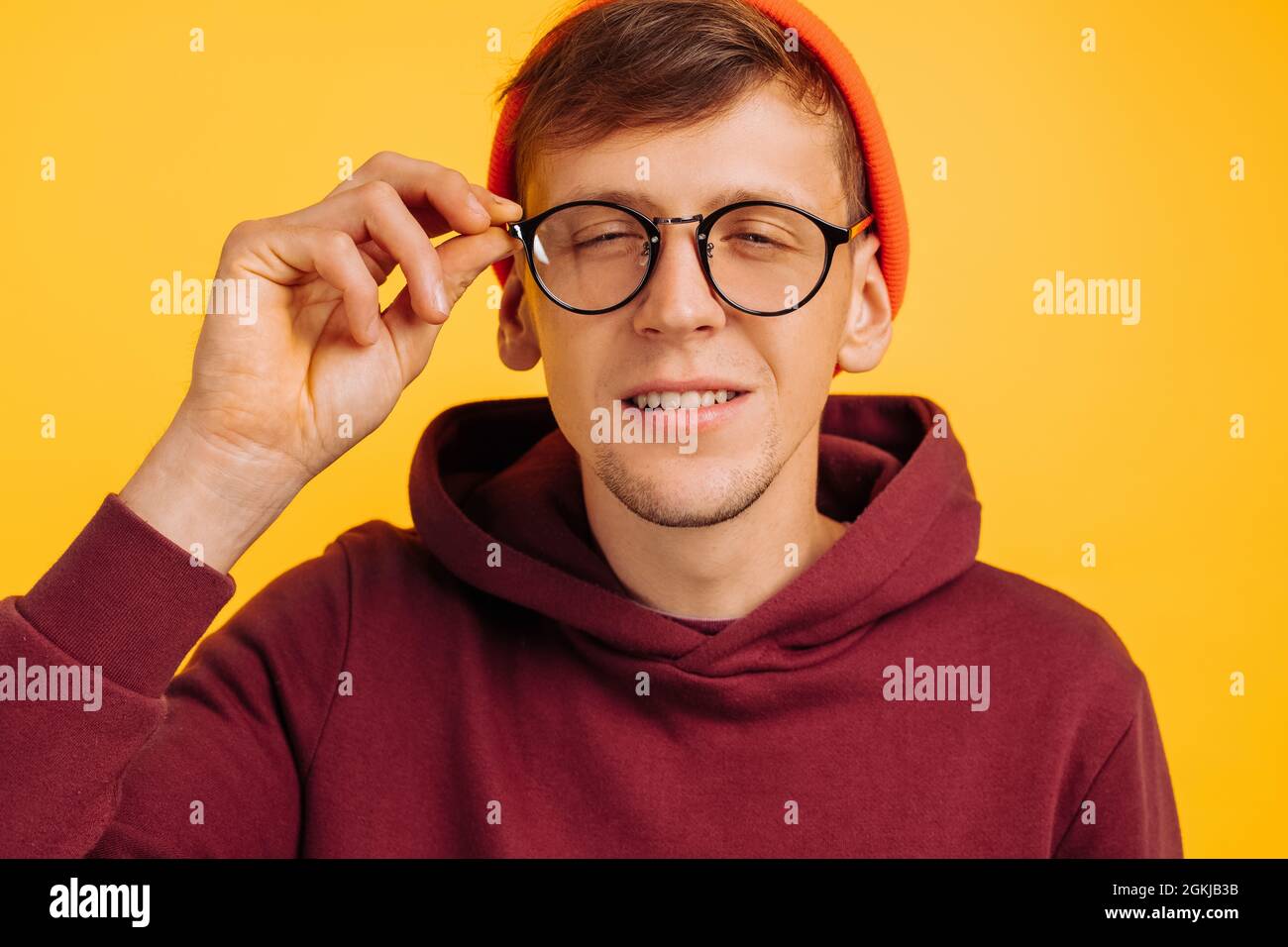 guy has poor eyesight, a handsome guy in an orange hat and red light