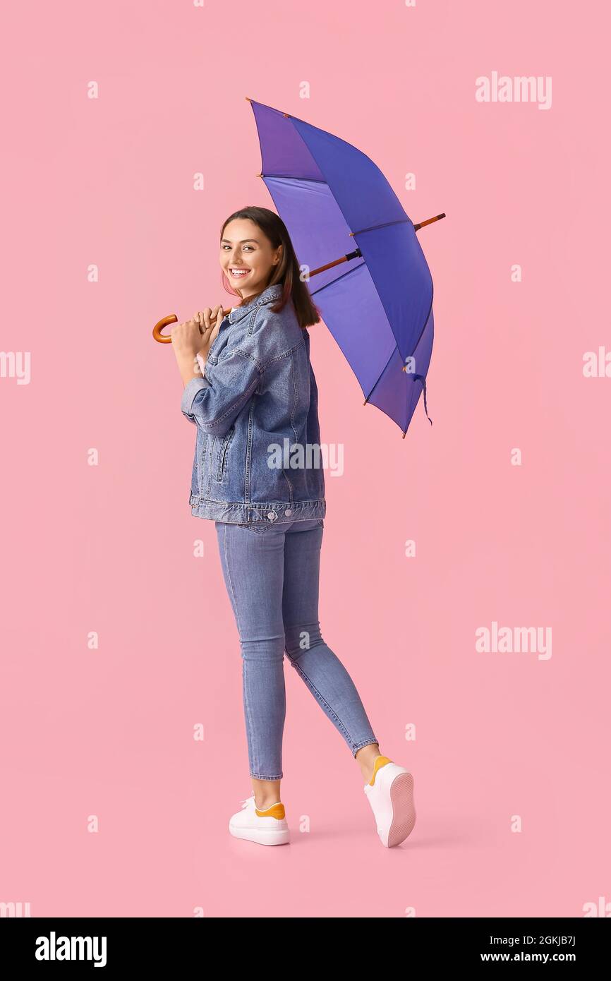 Beautiful young woman with umbrella on color background Stock Photo - Alamy